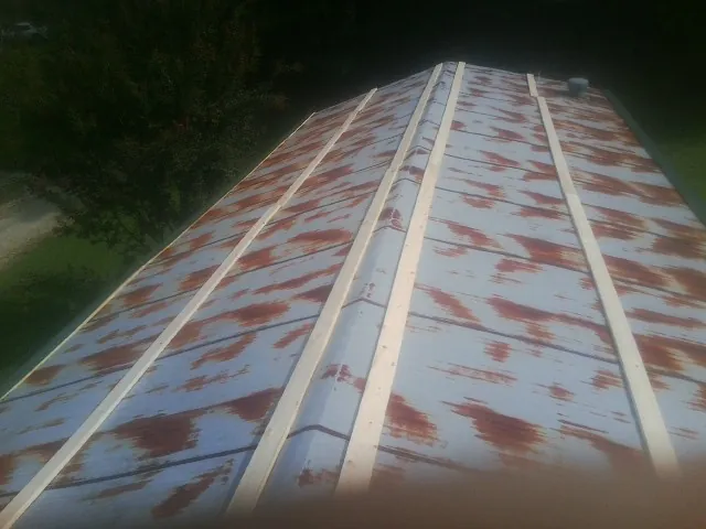 Rusted metal roof panels with new wood purlins before replacement — Storm Damage Roof Repair in Rochester Mills by Roofing Brothers